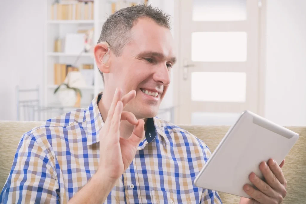 A man with a disability is using his tablet device to learn new things