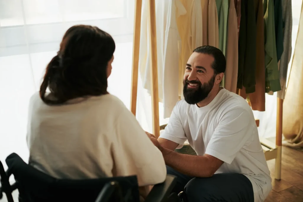 A woman in a wheelchair is receiving support by her care provider