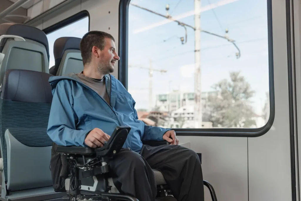 A man in a specialised wheelchair is travelling via the local train